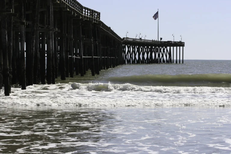 Ventura Pier viewed from the beach with ocean waves in Ventura California